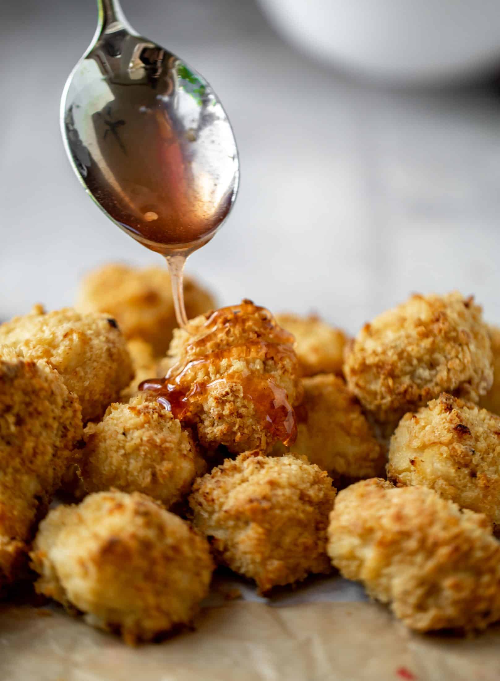 drizzling raspberry hot honey on popcorn chicken