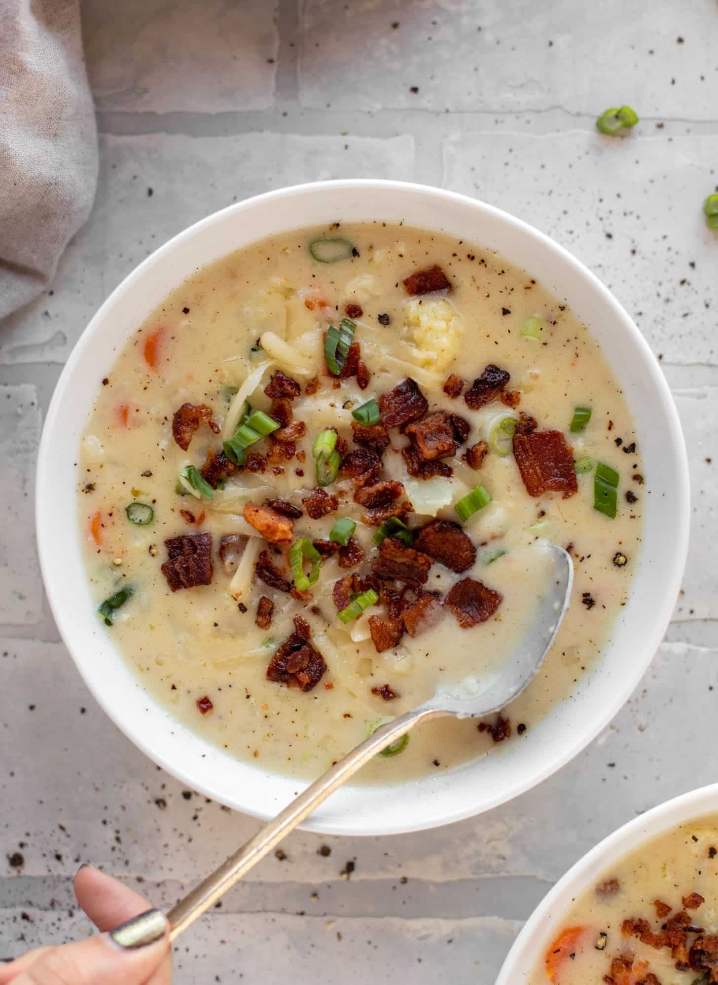 cheddar cauliflower chowder with bacon and a spoon