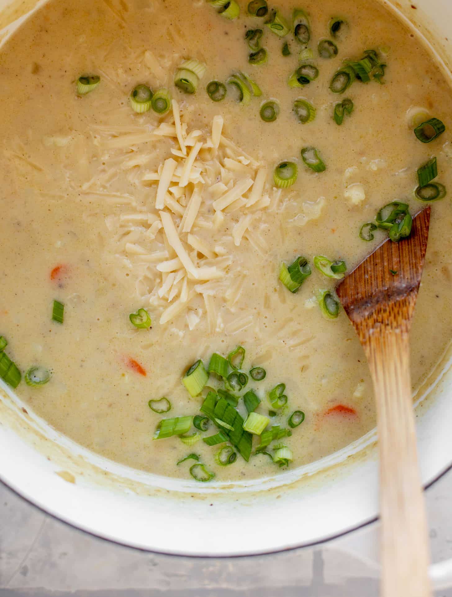 pot of cheddar cauliflower chowder with green onions