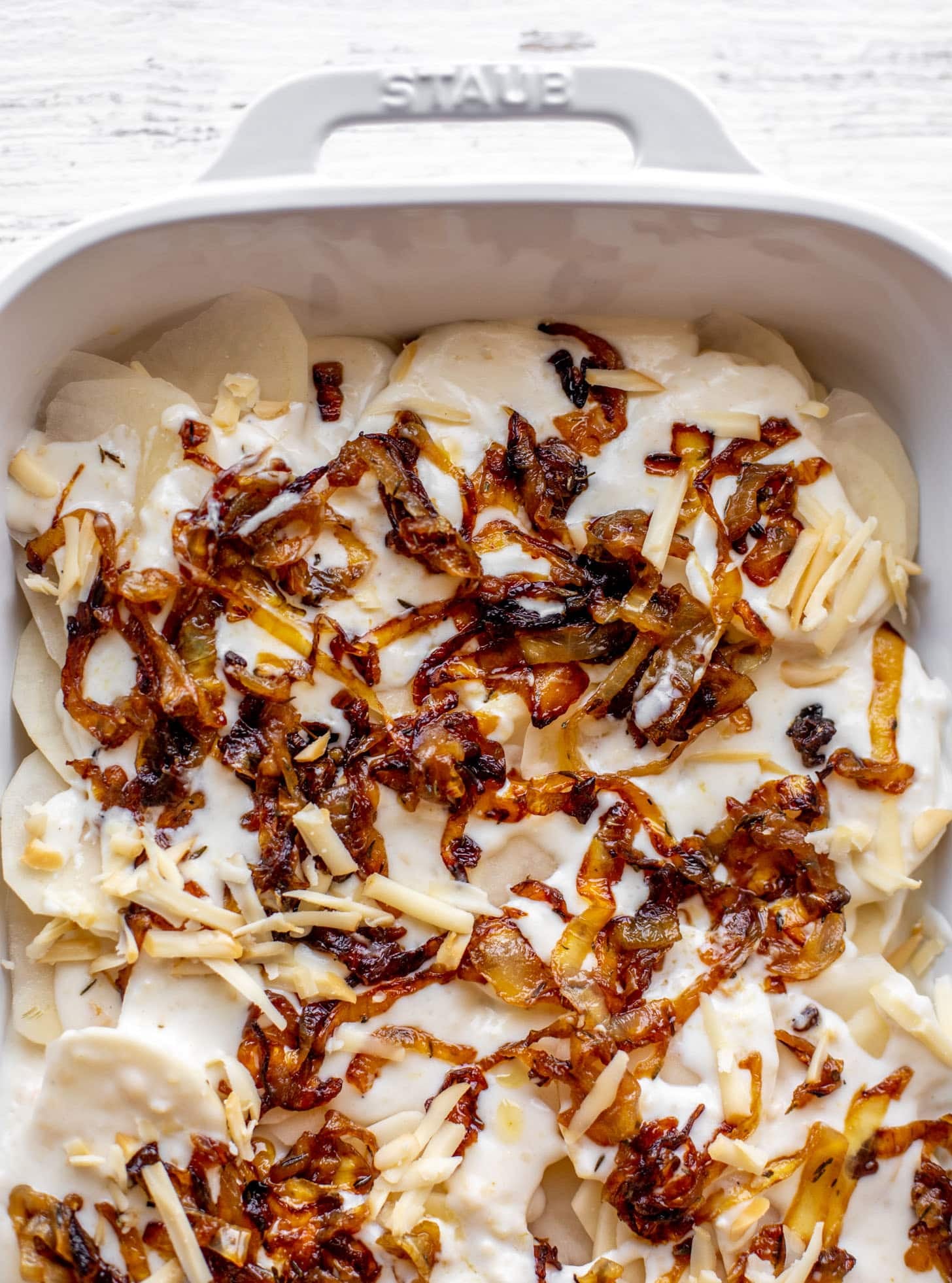 layering potatoes, sauce and caramelized onions