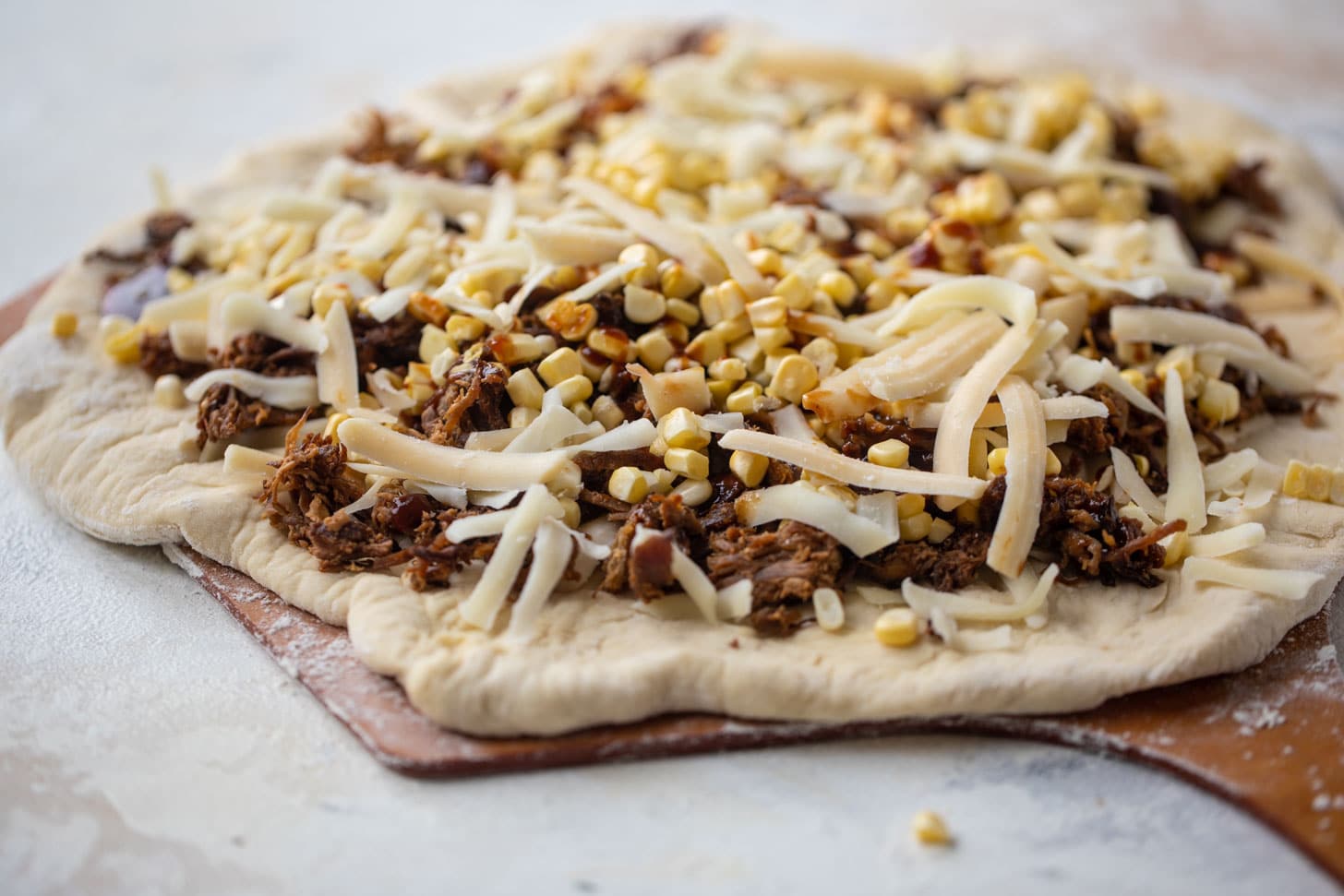BBQ pulled pork & sweet corn pizza ready for the grill