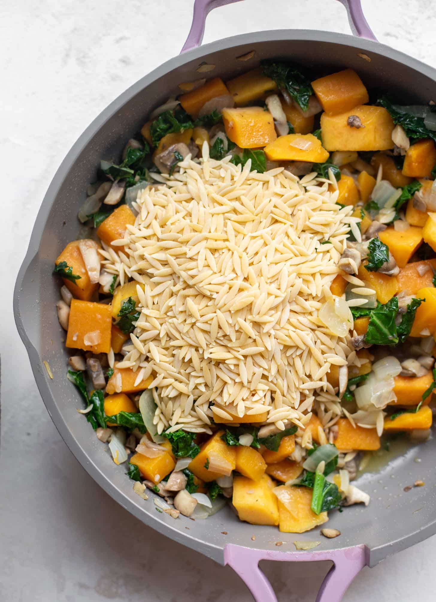 skillet with vegetables and orzo