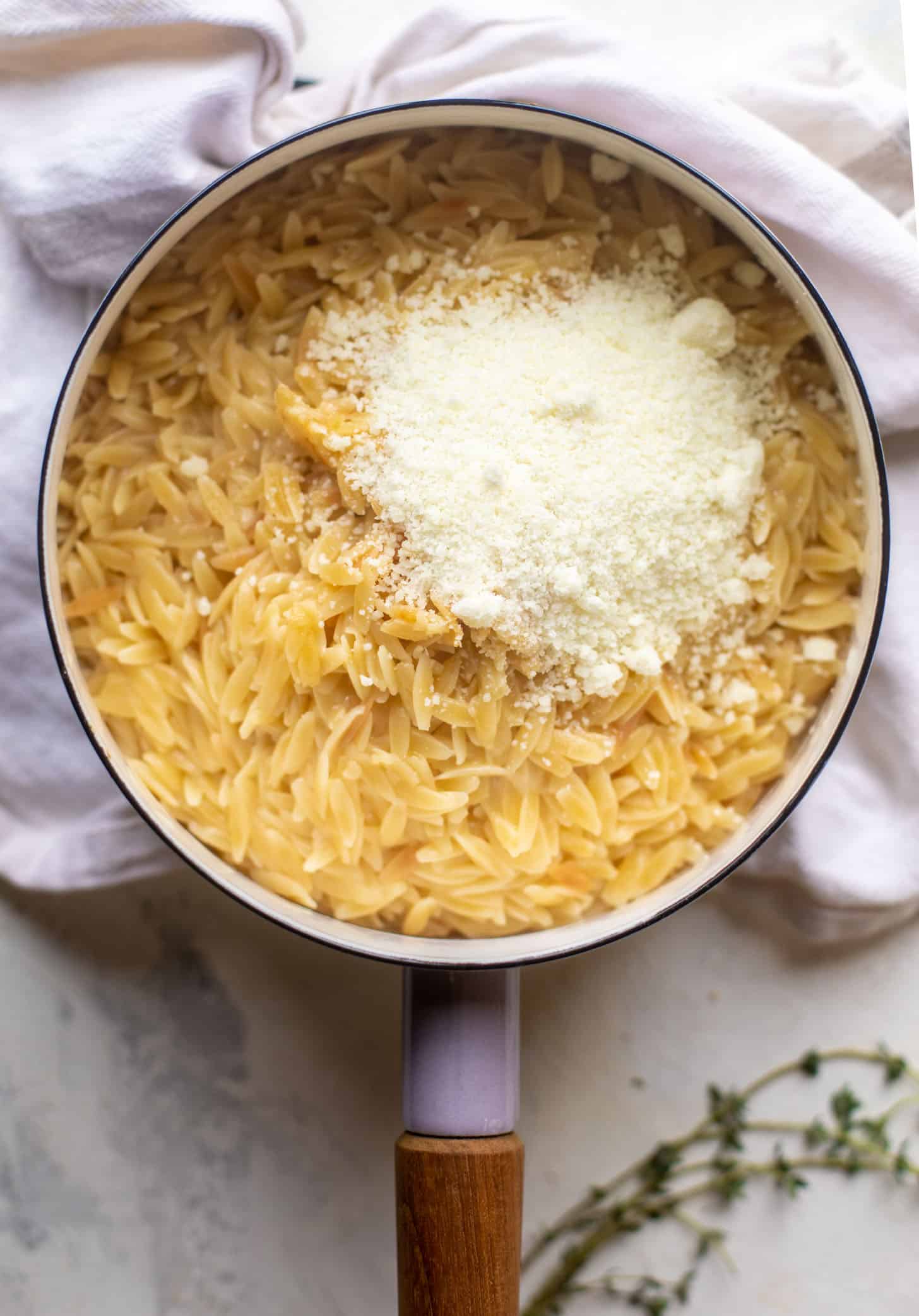 cooked orzo in a pot with parmesan cheese