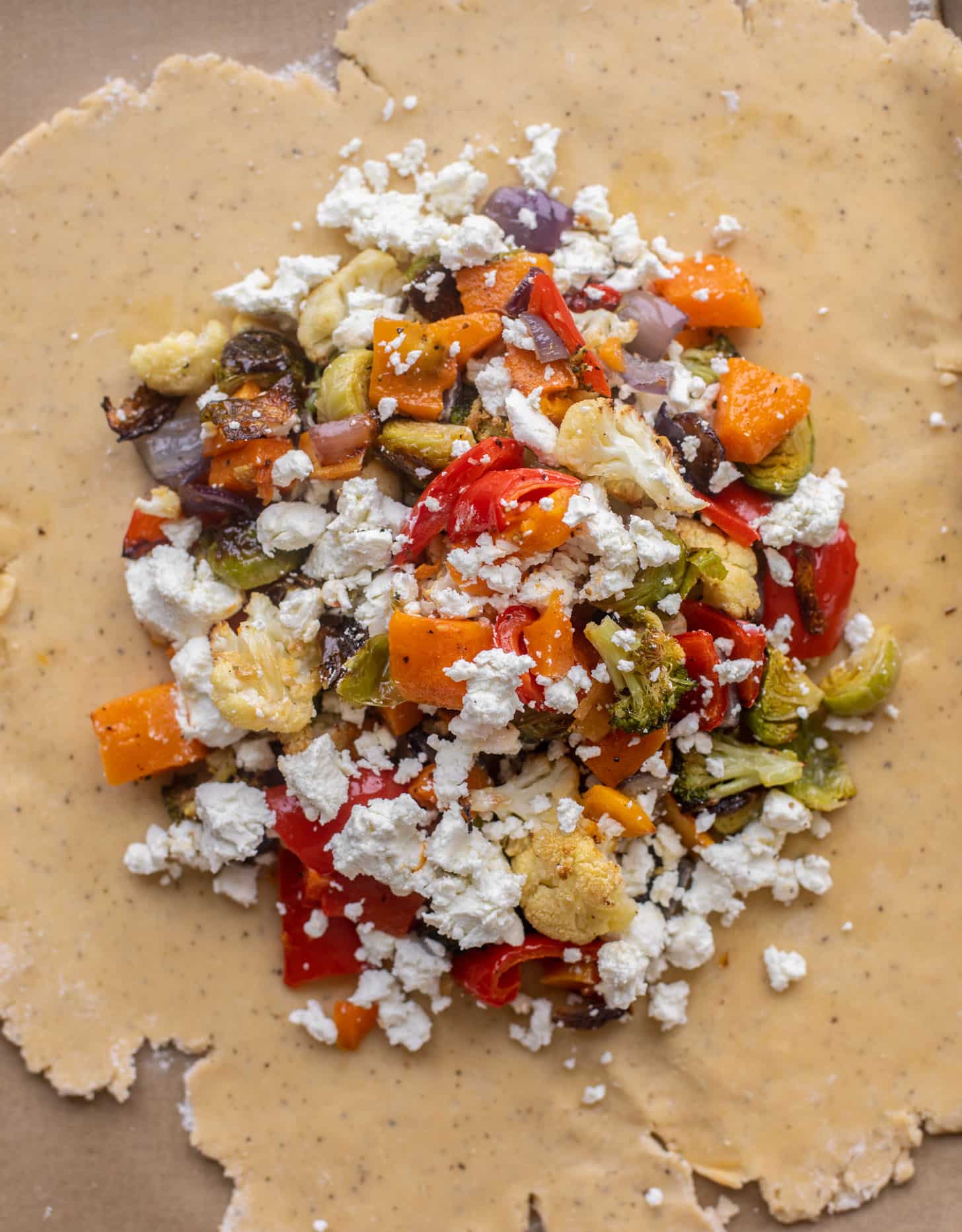 pie dough topped with vegetables and goat cheese