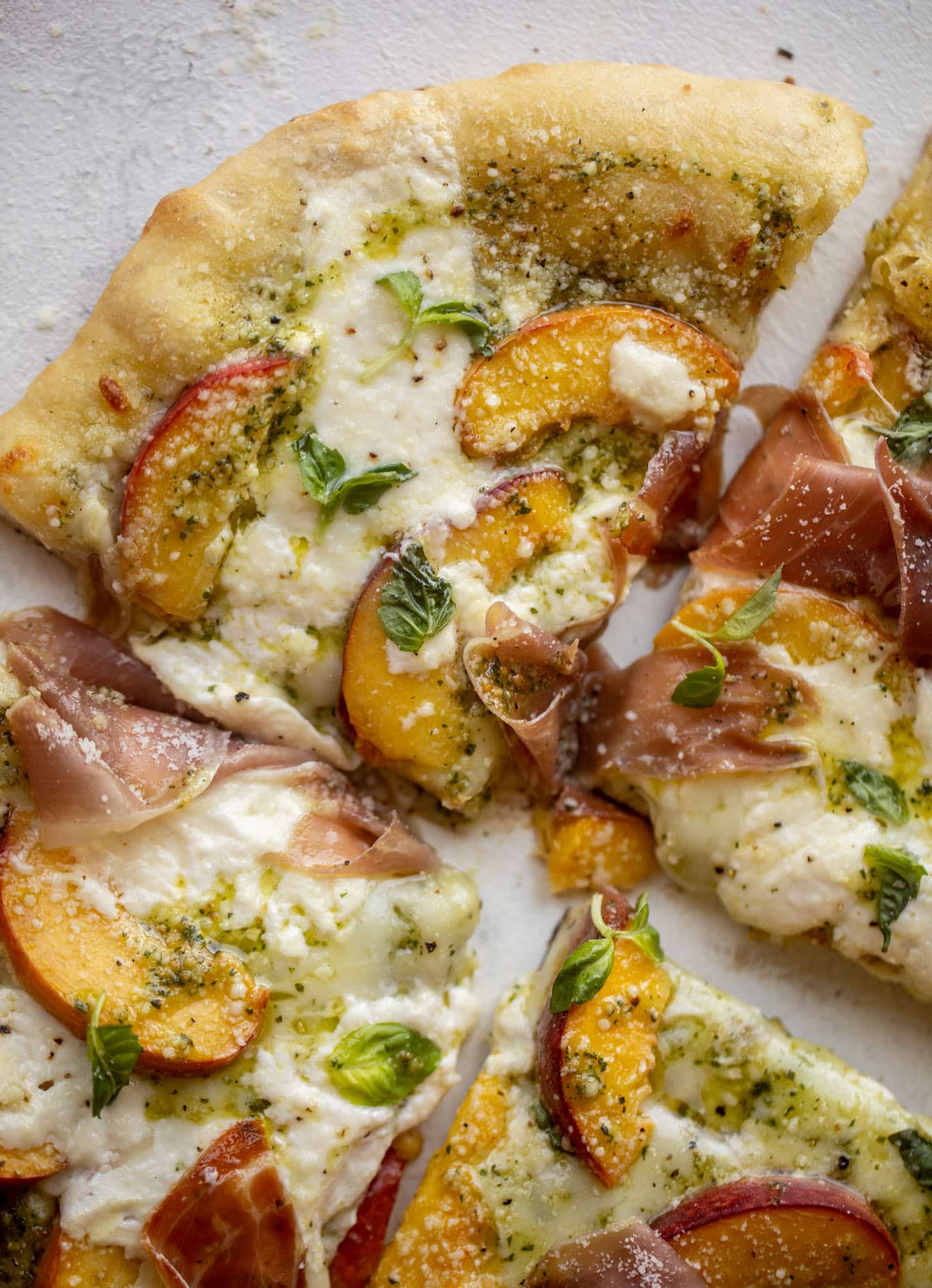 pesto peach pizza with prosciutto and burrata