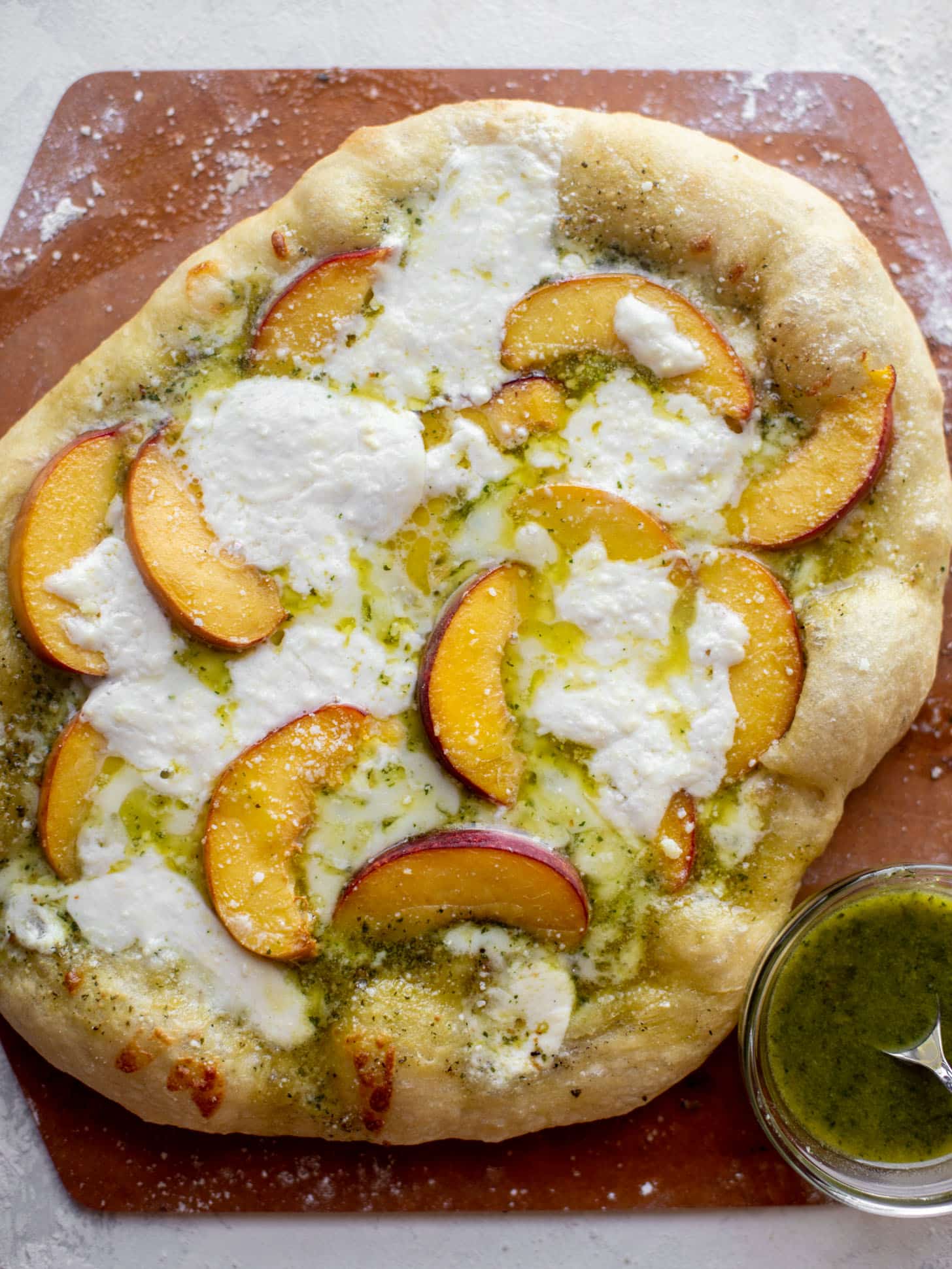 pesto peach pizza with prosciutto and burrata