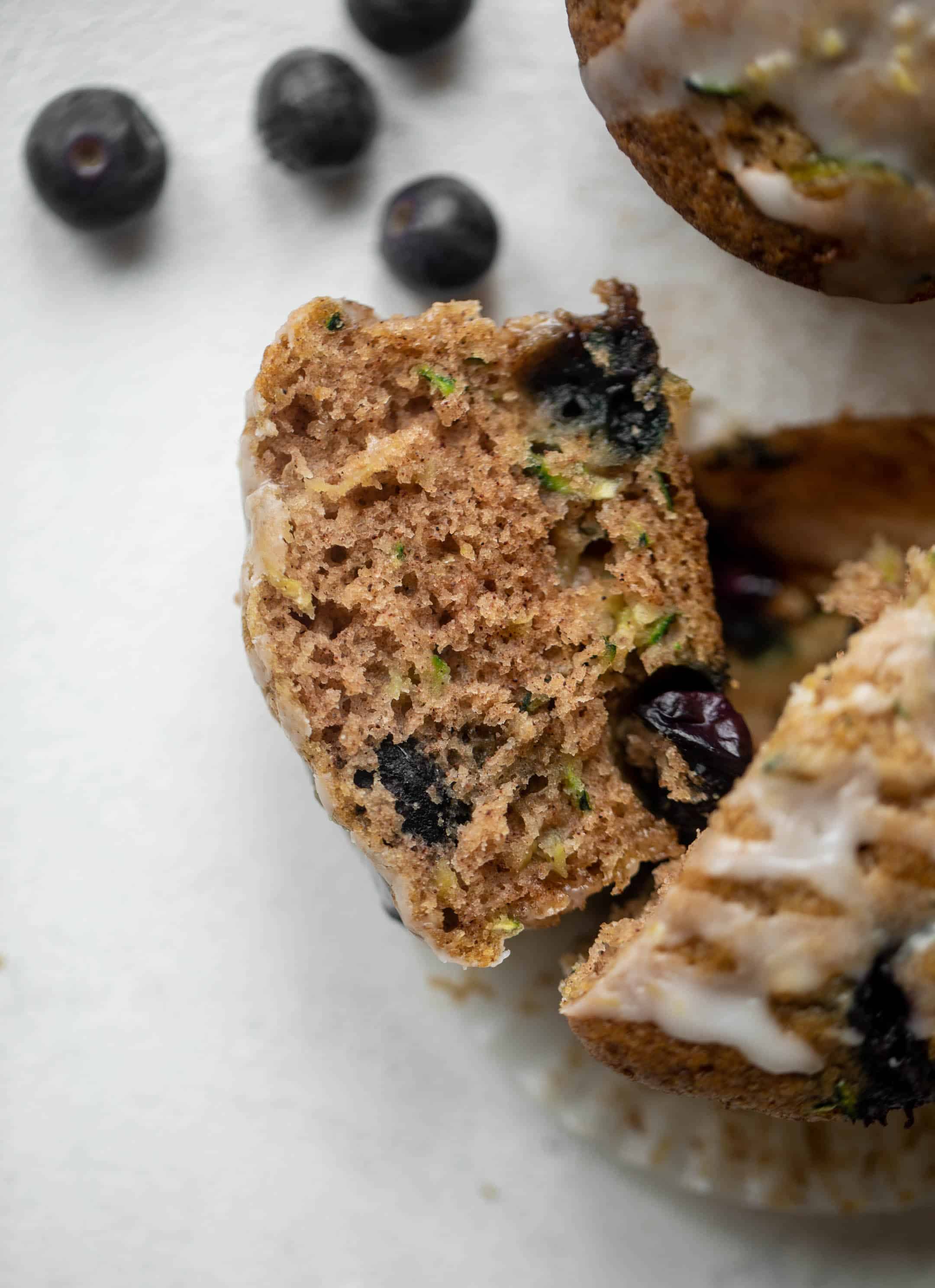 slice of blueberry zucchini muffins with lemon glaze